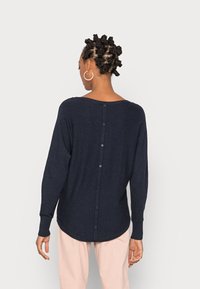 Maglione a maniche lunghe blu navy in maglia con scollatura ampia e dettaglio posteriore con bottoni, caratterizzato da una vestibilità rilassata e orlo curvo.