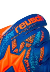 Guante de portero con diseño en azul y naranja, patrones hexagonales, agarre texturizado y un logo prominente en la correa.