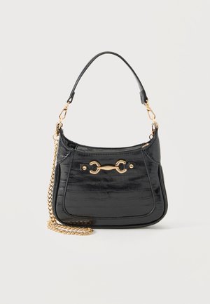 Black patent leather handbag with gold horsebit detail, short leather strap, and detachable gold chain on white background.