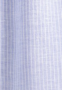 Tessuto azzurro chiaro, texture con sottili strisce bianche. Il materiale appare tessuto con una finitura morbida, mostrando un sottile motivo in tutto il suo sviluppo.