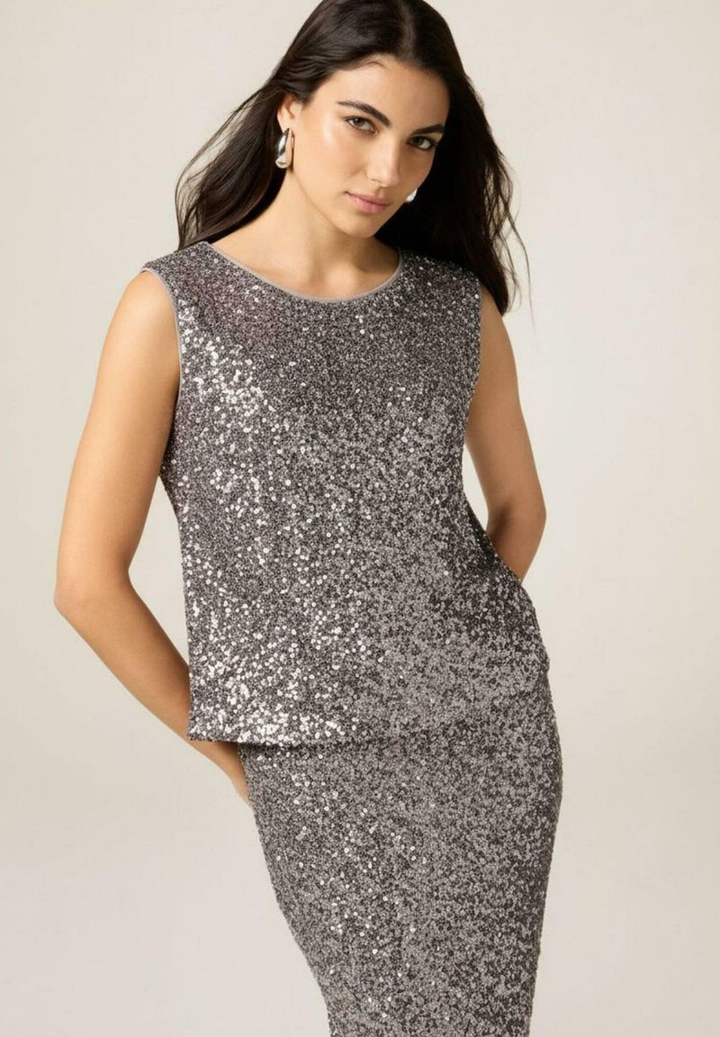 Srebrny top z cekinami o okrągłym dekolcie, bez rękawów, o luźnym kroju i gładkiej fakturze, zestawiony z pasującą cekinową spódnicą.