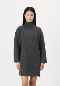 Grå ull turtleneck kjole med lange ermer, oversized passform og ribbestrikket tekstur, som når midt på låret. Enkelt design uten mønstre eller detaljer.