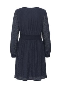 Abito di pizzo blu navy con maniche lunghe, vita stretta e motivi floreali. Il tessuto ha un aspetto delicato e texture.