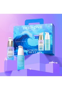 Hydratiseringssæt med tre flasker: blå og lilla emballage, guld- og hvide accenter, mærket "Good Genes" og "Tidal."