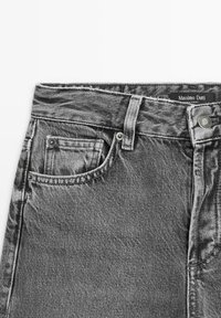 Close-up of grey denim jeans showing front pocket, belt loop, button, and visible brand label "Massimo Dutti."