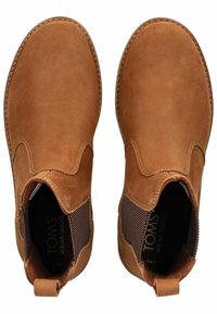 Botas de cuero marrón hasta el tobillo con paneles laterales elásticos, puntera redondeada y costuras contrastantes. Logo visible en la plantilla. Suela plana.