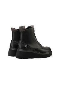 Stivali alla caviglia in pelle nera con suola spessa, lacci frontali, collarino imbottito e foderato a motivo che presenta un logo sul lato.