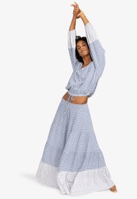 Blauw en wit gestreept twee-delig outfit met een losse top met een aantrekkoord en een vloeiende lange rok met een contrasterende zoom.