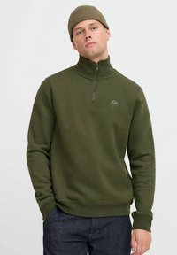 Oliven grønn zip-up sweatshirt med høy krage, ribbestrikkede mansjetter og en liten brodert logo på brystet. Glatt tekstur og tettsittende design.