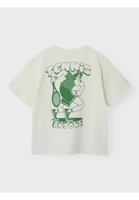 Cremefarbiges Baumwoll-T-Shirt mit einem grünen Grafikdruck eines Cartoon-Charakters, der einen Tennisschläger hält, und dem Text "TENNIS JEMAND?" darunter. Kurze Ärmel.