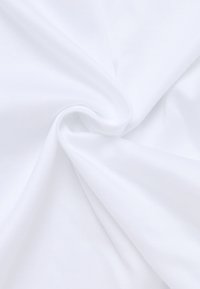 Witte stof met een gladde textuur, in zachte plooien gedrapeerd. Het oppervlak lijkt fris en schoon, zonder zichtbare patronen of versieringen.