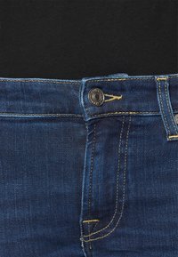 Dark blue denim jeans with yellow stitching, front button closure, and a smooth waistband. Feature straight legs and no visible patterns.