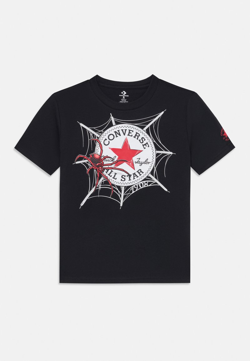 T-shirt noir avec un logo Converse rouge entouré d'une toile d'araignée, accompagné d'une illustration détaillée d'une araignée rouge près du logo.