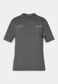 Gray short-sleeve t-shirt featuring a Chevrolet logo on the left and a Nike logo on the right in white embroidery. Cotton material.