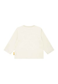 Cremfarbendes Langarmshirt, weiches Baumwollmaterial, runder Halsausschnitt, geripptes Bündchen und kleines Logotag an der Unterseite. Einfaches, schlichtes Design.