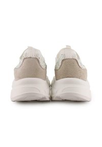 Zapatillas blancas con una zona del talón de ante beige, realzada por un patrón brillante en la parte trasera. Suela gruesa y texturizada para mayor soporte.