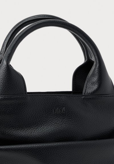 Μαύρη τσάντα από δερμα τυπωμένο με ανάγλυφη υφή, με δύο στρογγυλεμένες λαβές και διακριτικό ανάγλυφο λογότυπο "MM" στην εμπρόσθια πλευρά.
