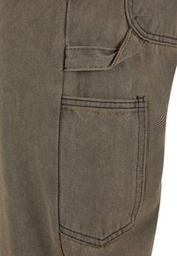 Bruine textuurstof cargobroek met een zijzak en zichtbare stiksels, in een slim-fit pasvorm.