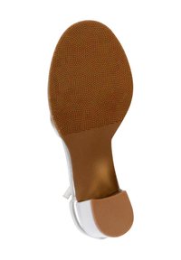 Suela de zapato de tacón alto blanca con un agarre de goma marrón con patrón, que presenta un refuerzo en el tacón texturizado y un borde superior suave y brillante.