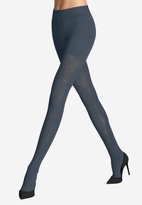 Collants à motifs bleus avec un design texturé, coupe ajustée aux jambes, et une taille haute, assortis à des escarpins noirs.