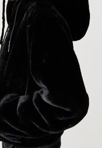 Black plush hoodie with a soft, fuzzy texture; features a drawstring hood and elasticized cuffs, designed for comfort and warmth.
