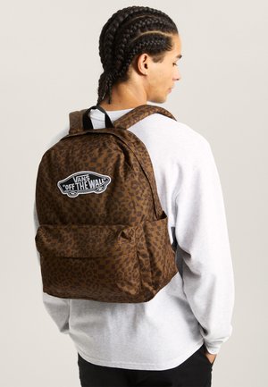 Sac à dos marron avec un imprimé léopard et un patch logo Vans sur le devant. Grand compartiment principal avec une poche avant et des bretelles réglables.