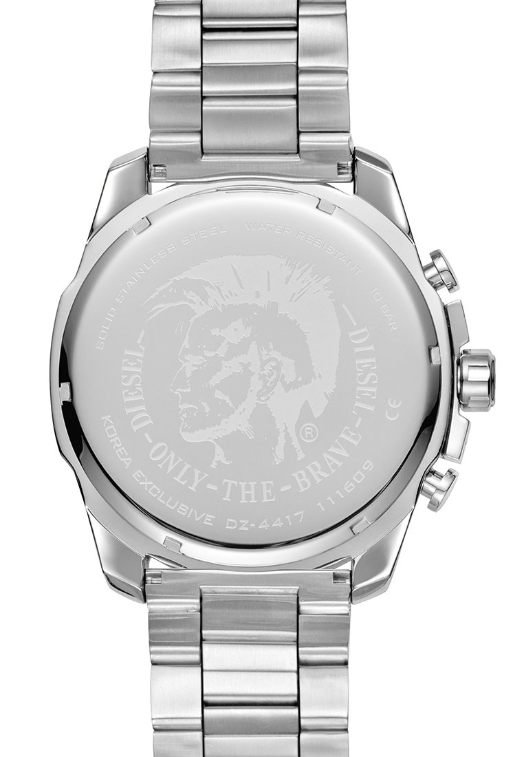 Reloj de acero inoxidable plateado con una caja robusta, que presenta un fondo circular suave grabado con una cara tribal y detalles textuales.