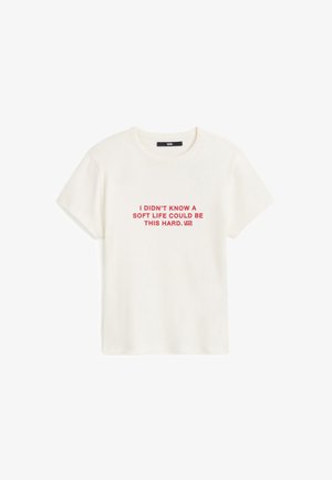 T-shirt blanc en coton avec manches courtes et col rond. Texte imprimé en rouge : « JE NE SAVAIS PAS QU'UNE VIE FACILE POUVAIT ÊTRE AUSSI DIFFICILE. »