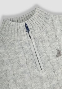 Világosszürke, cable knit (kötött) pulóver magas gallérral, rövid cipzárral és a mellkasán egy kis szürke vitorlás hajóra vonatkozó emblémával. Texturált anyag.
