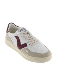 Sneaker bianco con accento in suede bordeaux e punta in suede beige. Presenta una parte anteriore perforata, lacci color crema e un branding sottile sulla linguetta.
