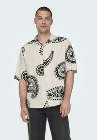 Kurzarmhemd in Cremefarbe mit schwarzem Paisleymuster, leichtes Material, durchgehende Knopfleiste und Spread-Kragen.