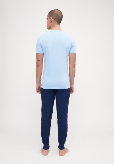 Light blue short-sleeve t-shirt paired with navy blue sweatpants. The outfit features a fitted design and soft fabric texture.
