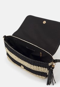 Splotkowana torebka kopertowa w czarno-kremowy paskowany wzór, z magnetycznym zapięciem i wewnętrzną kieszonką; posiada skórzane akcenty oraz szczegół w postaci frędzli.