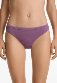 Perizoma viola a coste con un design a vita bassa. Presenta una copertura minima e sottili fasce laterali, realizzato in un materiale elastico per costumi da bagno.