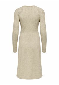 Beige gebreide jurk met lange mouwen, geribbelde textuur en een aansluitende taille, die naar de zoom toe taps toeloopt. De achterkant toont een subtiel kabelpatroon.