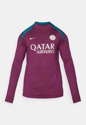 Maglia sportiva a maniche lunghe di colore viola con colletto a mezza zip. Presenta accenti sui fianchi di colore teal e il logo "QATAR AIRWAYS" in oro. Emblema Nike sul petto.