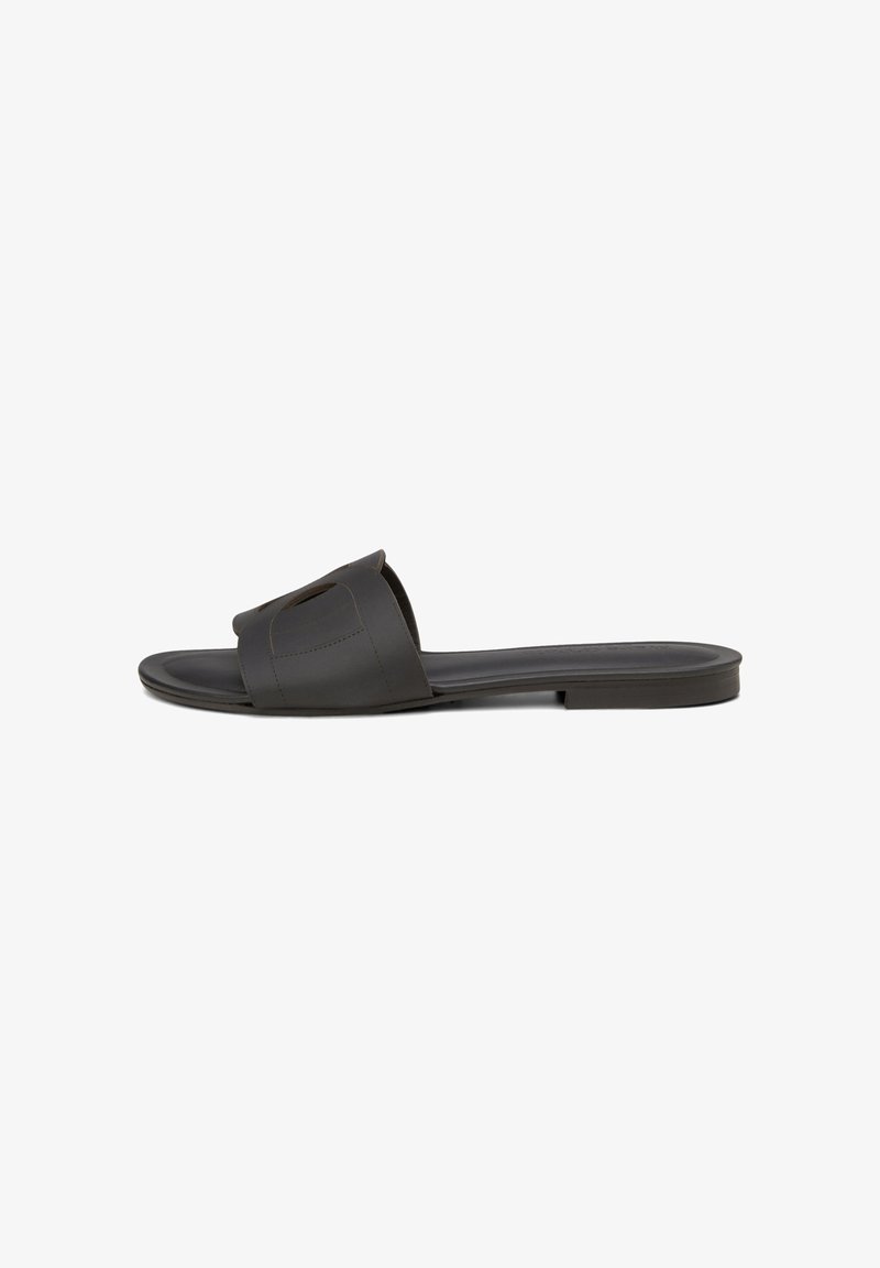 Des sandales noires à glissière avec une large bande sur le pied, présentant un design minimaliste et une semelle plate pour le confort.