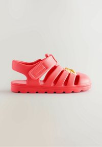 Sandale en caoutchouc corail à design ouvert, bride ajustable et semelle texturée. Présente des accents décoratifs jaunes à l'avant.