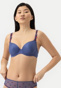 Navy blue bra with molded cups, floral embroidered straps in red and purple. Smooth texture, underwire support, and a seamless design.
