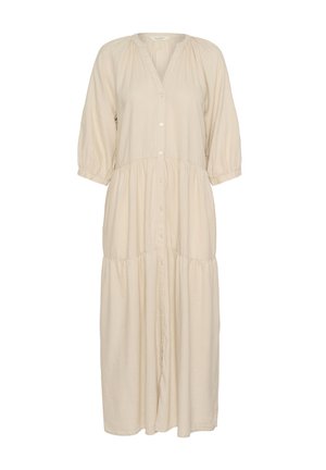 Hosszú bézs színű ruha gombos elejével, gyűrt vállvarrásokkal és réteges szoknyával. Könnyű, puha anyagból készült. Háromnegyedes ujjakkal rendelkezik.