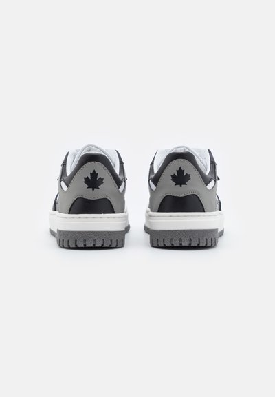 Sneaker nere e grigie con suole bianche, dotate di una suola in gomma testurizzata e di un accento a forma di foglia di acero sul tallone. Design standard dei lacci.