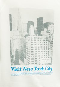 Φωτογραφία του ορίζοντα της Νέας Υόρκης ασπρόμαυρη με ψηλά κτίρια, κείμενο "Visit New York City" με μπλε χρώμα, και μικρό λογότυπο kate spade.
