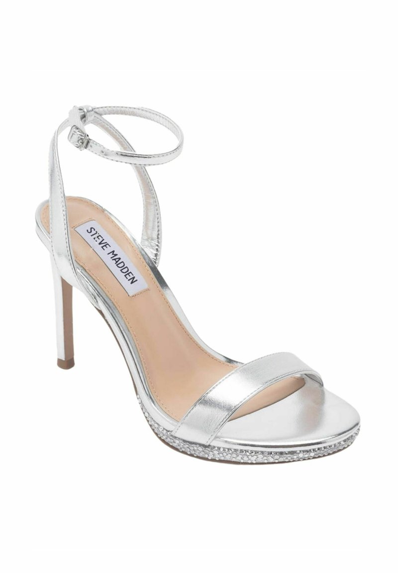 Sandale à talons hauts argentée avec une finition métallique, bride de cheville, large bande avant et plateforme ornée d'accents en strass.