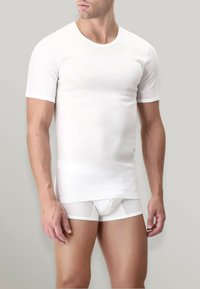 T-shirt bianco a maniche corte realizzato in materiale liscio, design aderente, abbinato a boxer bianchi con dettagli in pannello traslucido.