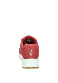 Scarpa sportiva rossa con tomaia liscia, dettagli forati, tallone imbottito, suola intermedia bianca e suola esterna testurizzata per garantire aderenza.