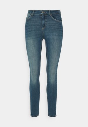 Jeans skinny in denim con una lavatura blu medio, caratterizzati da una chiusura a bottone standard, design a cinque tasche e leggere aree di scolorimento.