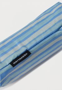 Trousse à crayons en tissu rayé bleu avec fermeture éclair. Logo Marimekko cousu sur une étiquette noire. Texture lisse avec des lignes horizontales.
