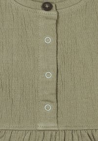 Khaki-Kleidungsstoff mit strukturiertem Finish, runder Ausschnitt, ein brauner Knopf und drei weiße Knopflöcher. Raffinierter Saum.