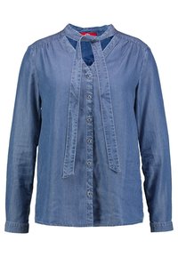 Camicia di denim azzurro chiaro con colletto a banda. Presenta una chiusura frontale con bottoni e un dettaglio con un nodo sul collo. Maniche lunghe con polsini abbottonati.