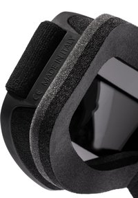 Dispozitiv ergonomic negru, cu țesătură moale și accente de cauciuc. Dispune de curele ajustabile și un etichetă care indică "FABRICAT ÎN ITALIA".